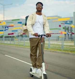 person with glasses on electric scooter